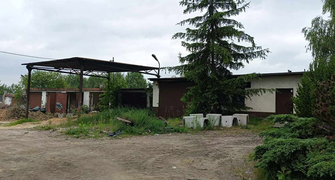 Zdjecie przedstawia zniszczony budynek oraz teren przed nim