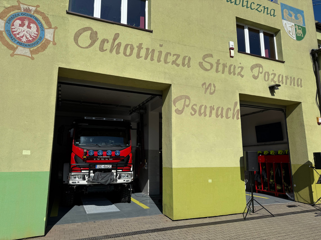 Zdjęcie przedstawia remizę strażacką wraz z wozami