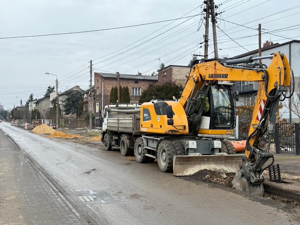 Zdjęcie przedstawia koparkę wykonującą prace ziemne przy budowie kanalizacji deszczowej