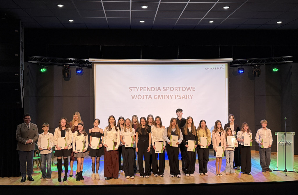 Zdjęcie przedstawa grupę stypendystów sportowych na scenie
